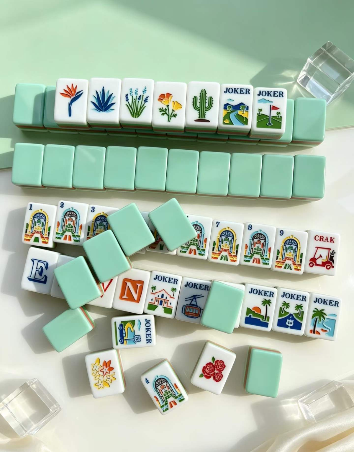 The Riviera Club botanical and Joker tiles displayed beside pale green tile backs
