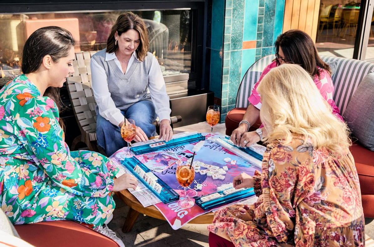 Friends gathering around an American mahjong table